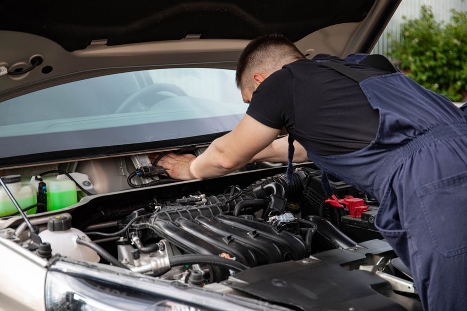 Mecánico trabajando en el motor de un auto — foto de la demo de taller